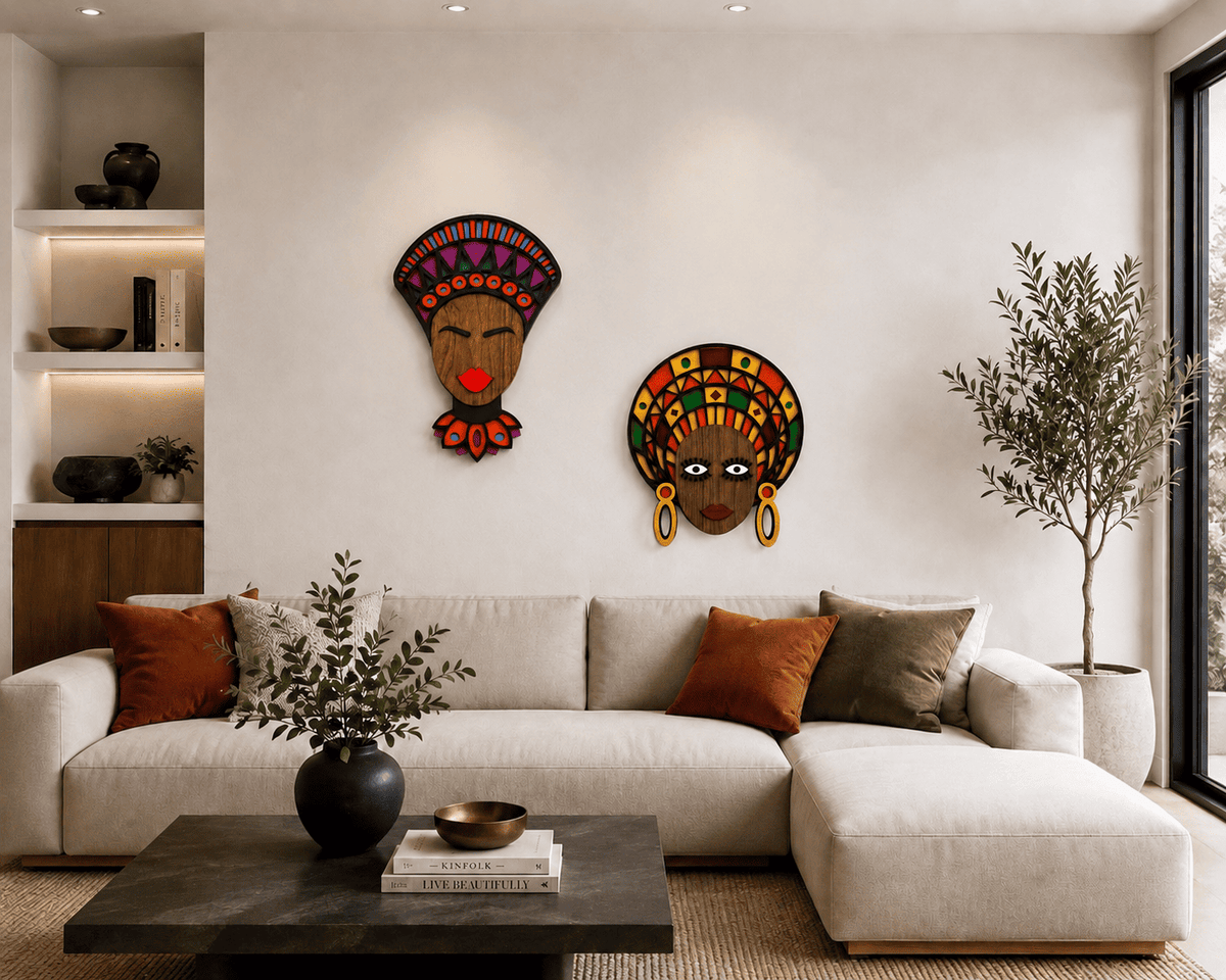 Two colorful African-style decorative wall masks hang above a light beige sectional sofa in a modern living room with a dark coffee table, shelving, and a potted tree.