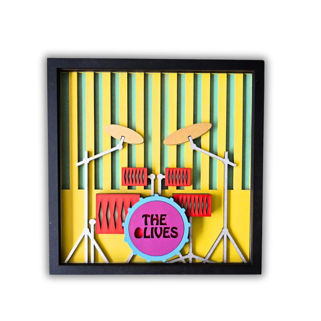 Framed artwork of a drum set with 'The Clives' on a yellow background