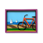 A colorful 3D layered shadow box art print featuring an orange bicycle on a beach with blue water and white sailboats, enclosed in a purple frame - umasqu