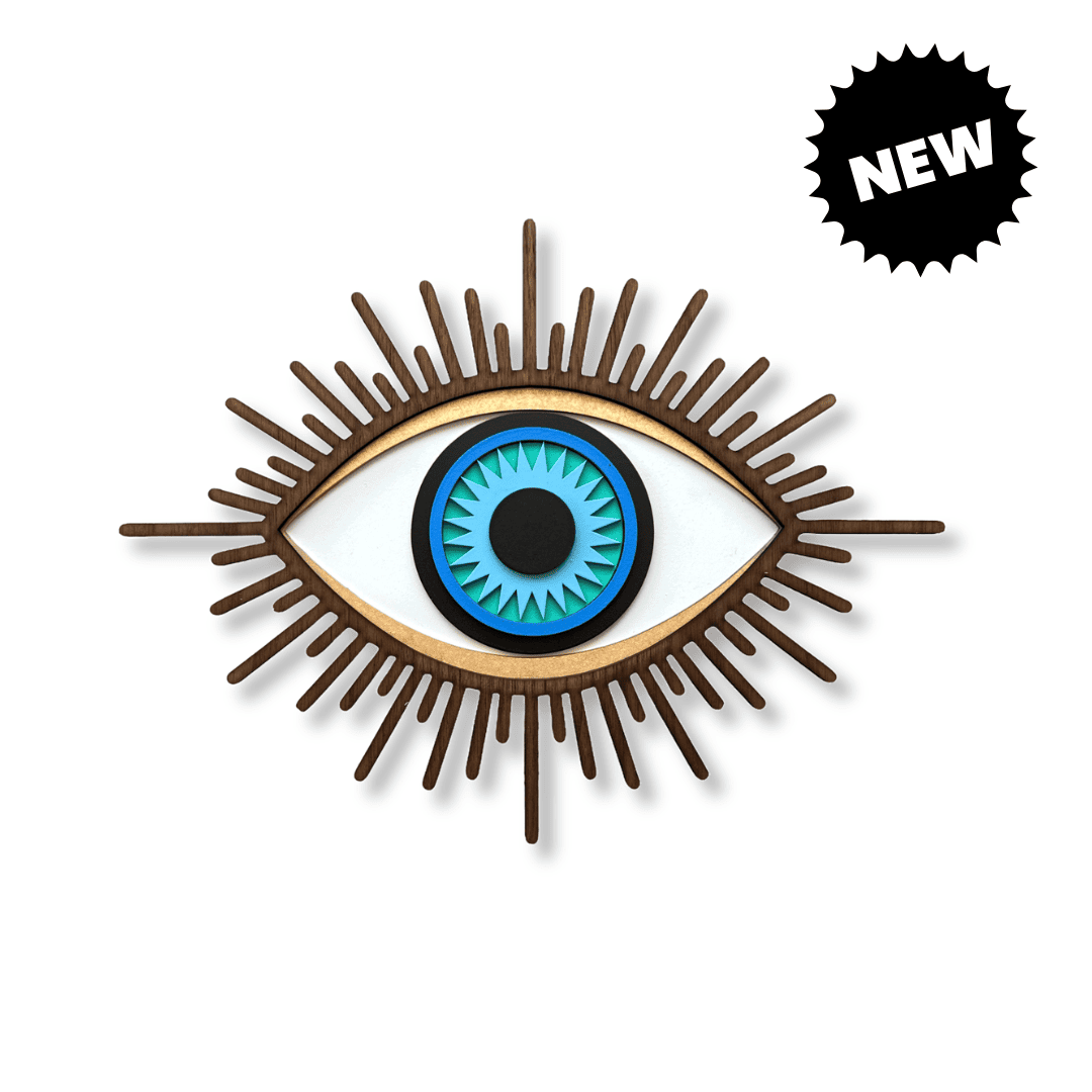 A decorative wall art piece shaped like an eye, with a blue and black iris, white sclera, and brown radiating rays. 
