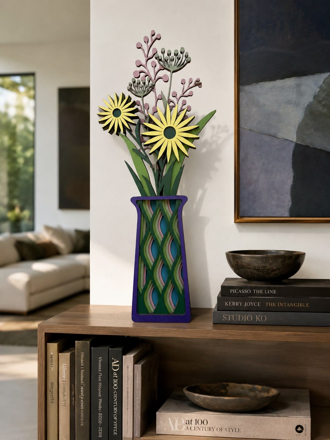 A decorative floral arrangement in a patterned blue, green, and purple vase, displayed on a wooden shelf in a modern living room setting.